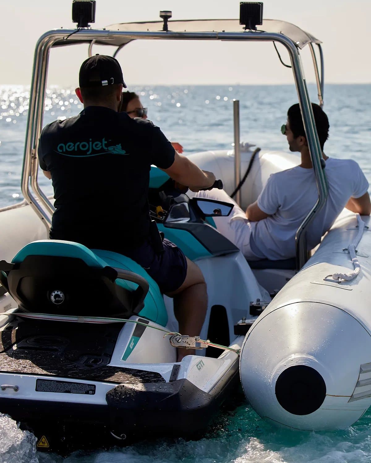 Δύο επιβάτες στο κατάστρωμα, με το jet ski κουμπωμένο μπροστά τους