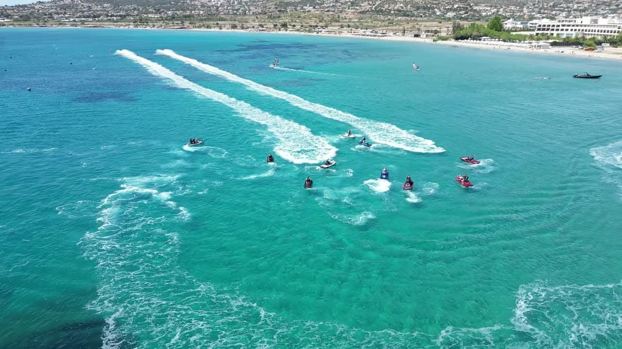 Από ψηλά: η παρέα με τα jet ski στα ανοιχτά, με τα απόνερα να γράφουν γραμμές στο νερό